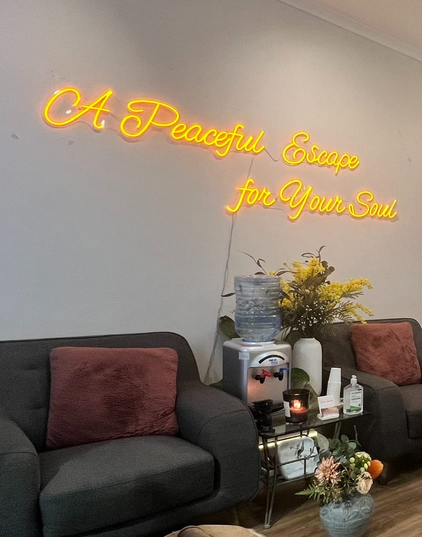 Neon sign reading A Peaceful Escape for Your Soul above the lounge