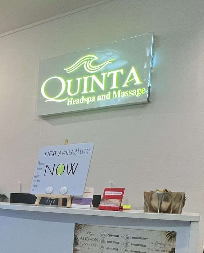 The lit Quinta Headspa and Massage sign above the reception desk